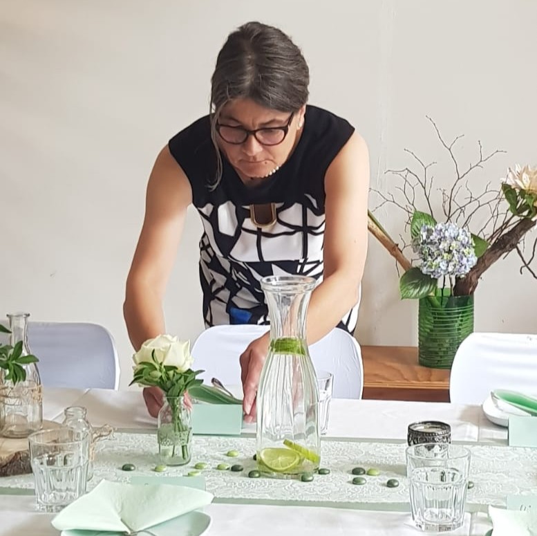 Eventmanagerin richtet Tischdekoration her
